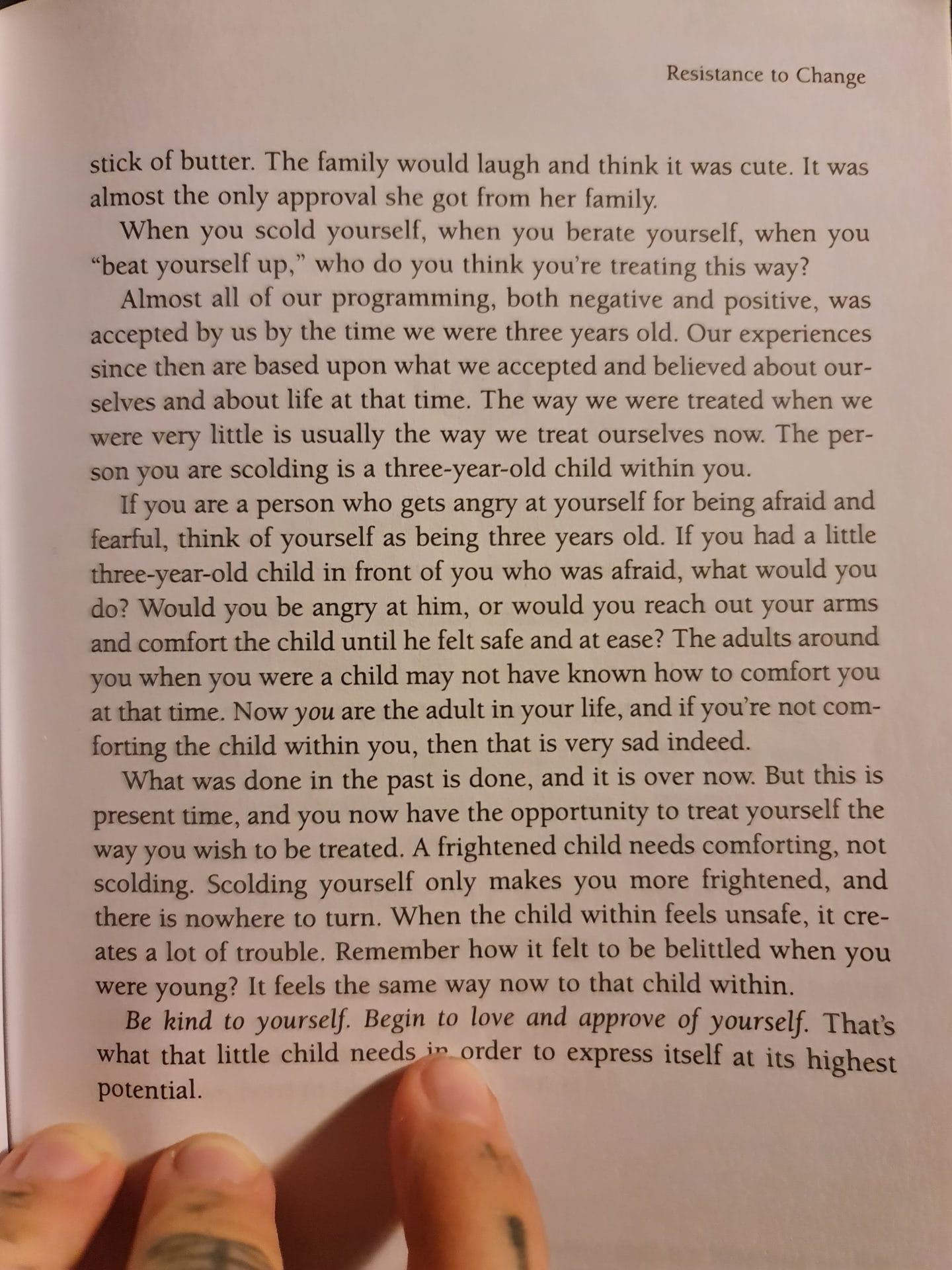 Sover Travel - A person holding an open book titled Resistance to Change, showing a page discussing childhood experiences, self-acceptance, fear, and compassion. The deep text encourages empathy towards ones inner child.