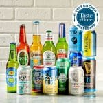 Sover Travel - A selection of non-alcoholic beer bottles and cans are artfully arranged against a white brick wall, evoking the spirit of a sober explorer. A Taste of Home Test Kitchen Preferred badge is proudly displayed in the top right corner.