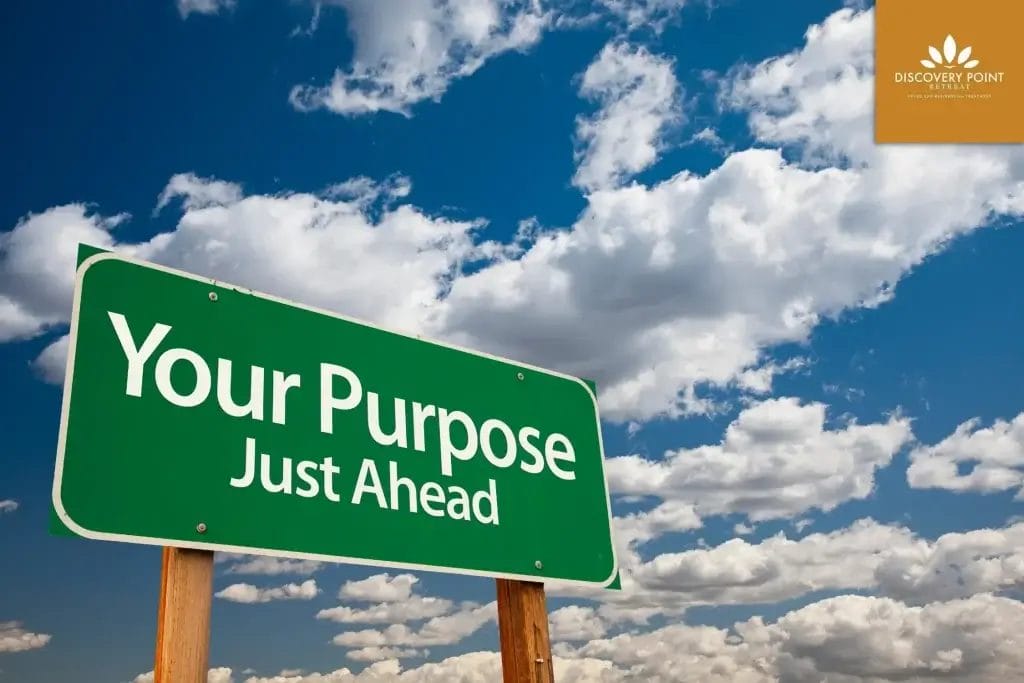 **Alt Text:** Green road sign reading "Your Purpose Just Ahead" against a blue sky with clouds. **Caption:** A reminder to embrace your journey towards wellness and self-discovery. **Image Description:** A green sign indicating "Your Purpose Just Ahead" set against a scenic sky.