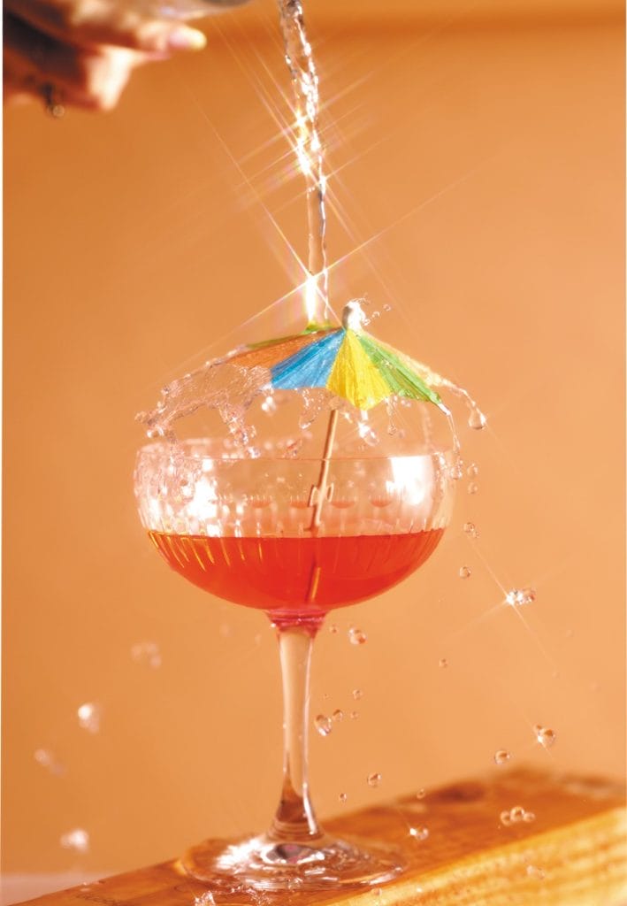 **Alt Text:** A colorful cocktail glass with a tiny umbrella, splashing water in a vibrant setting. **Caption:** Refreshing moments captured—perfect for mindful sipping and enjoying life’s little pleasures. **Image Description:** A cocktail glass with a colorful umbrella, showcasing splashes of water against a warm backdrop.