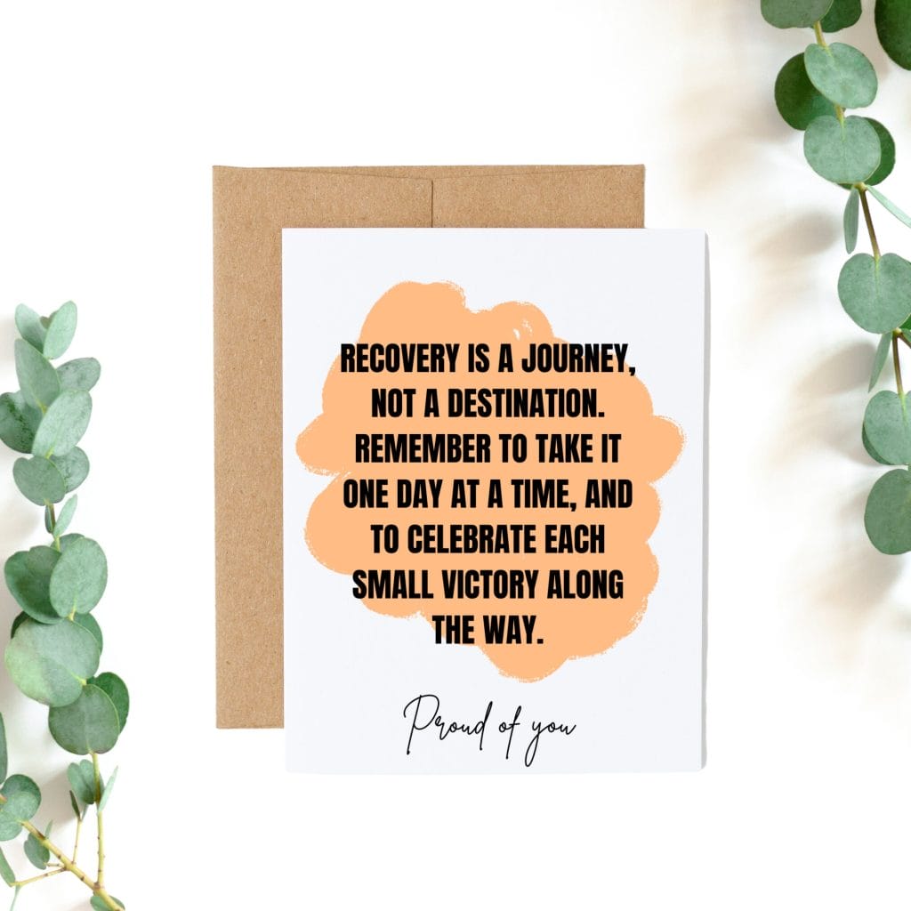 Sover Travel - A greeting card on a brown envelope surrounded by eucalyptus leaves. The card displays an orange paint splotch with the words: Recovery is a journey, not a destination. Celebrate each sober milestone along the way and take it one day at a time. Proud of you.